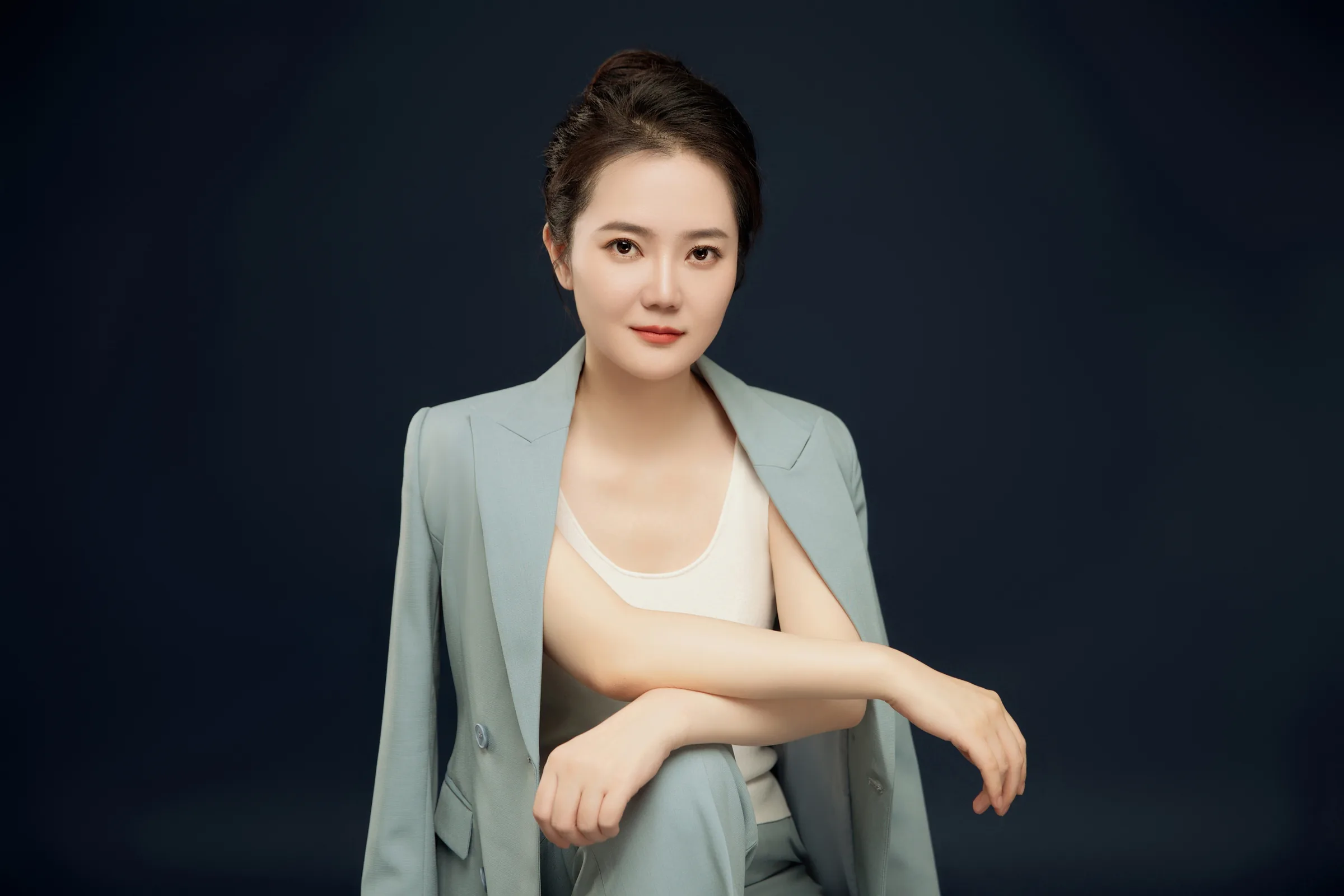 Retrato profesional de Teresa Gao con traje azul claro.